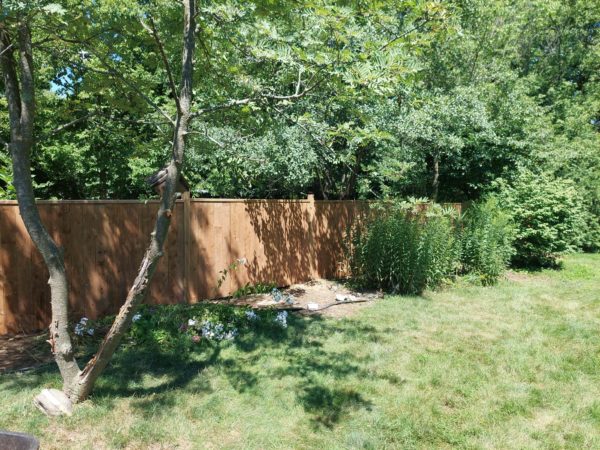 backyard fence build, covered in grass